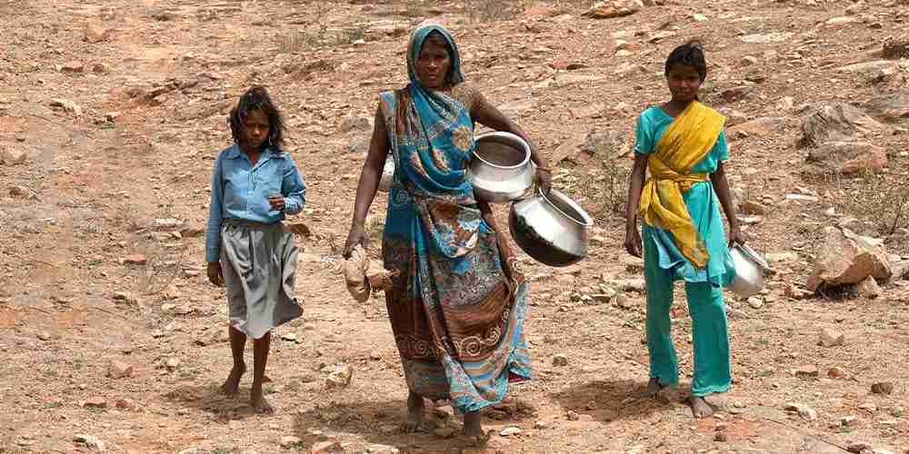 Women like these walk long distances in order to draw water into their containers, and often the water the obtain is impure