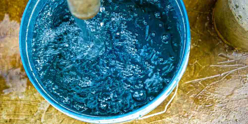 Bucket being filled with clean water from Jesus Wells
