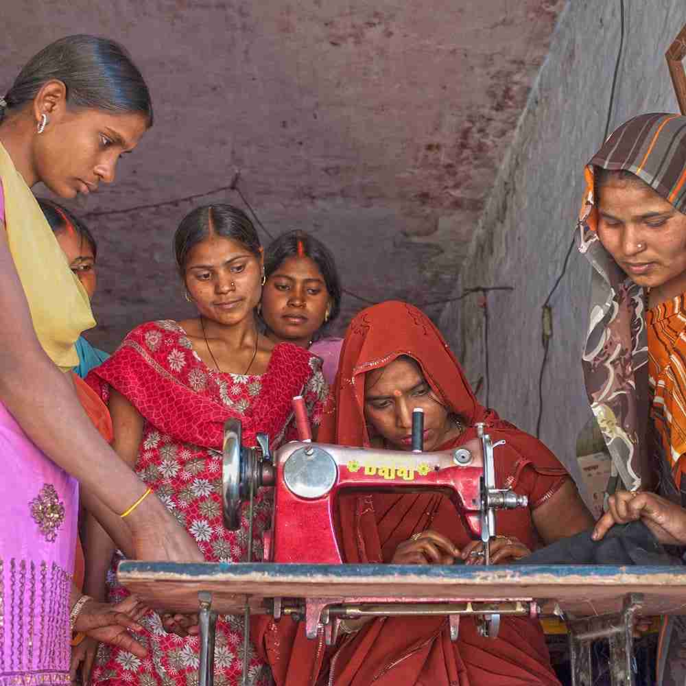 Group of women receiving sewing machine vocational training