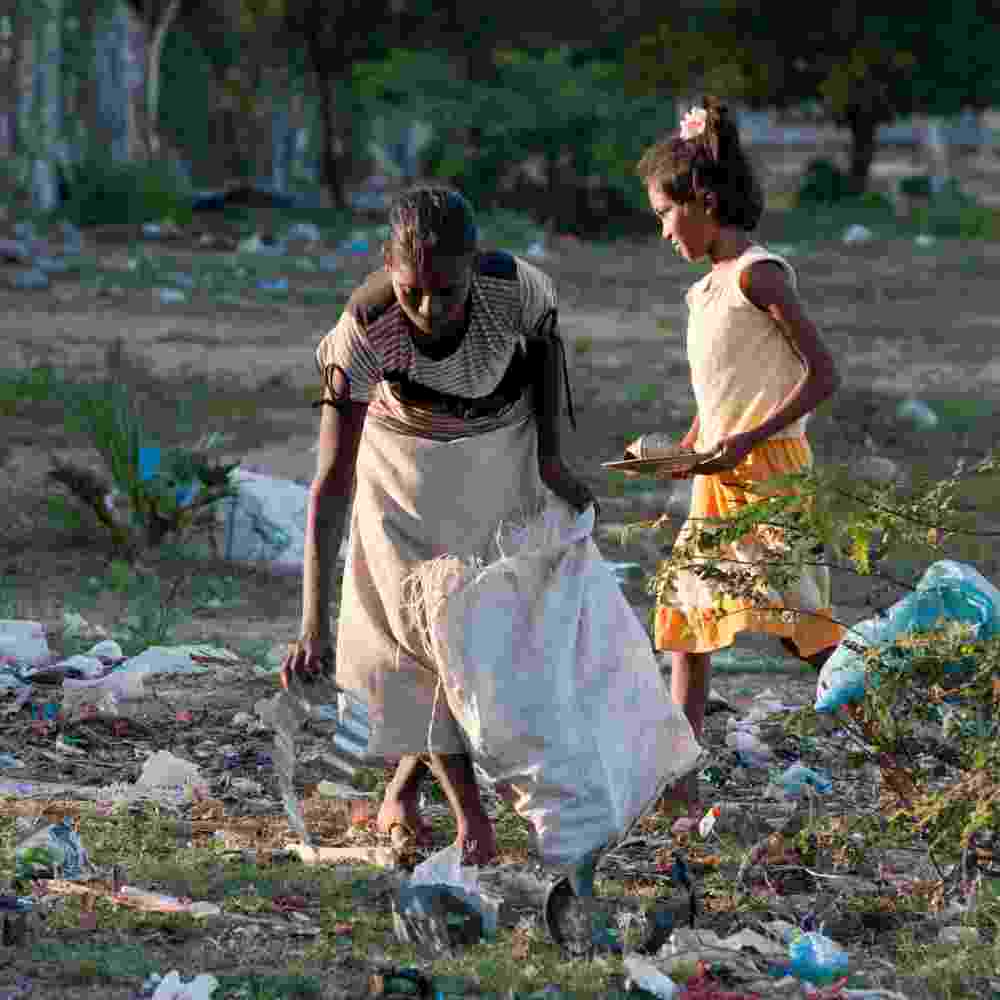 A mother and daughter in poverty in Asia, sifting through garbage to earn some money