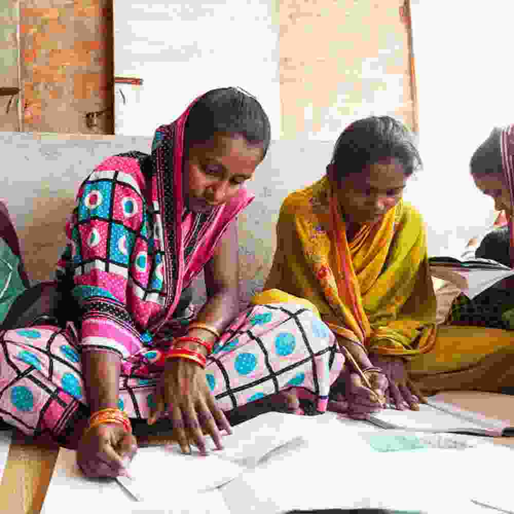 Women writing in GFA World adult literacy class