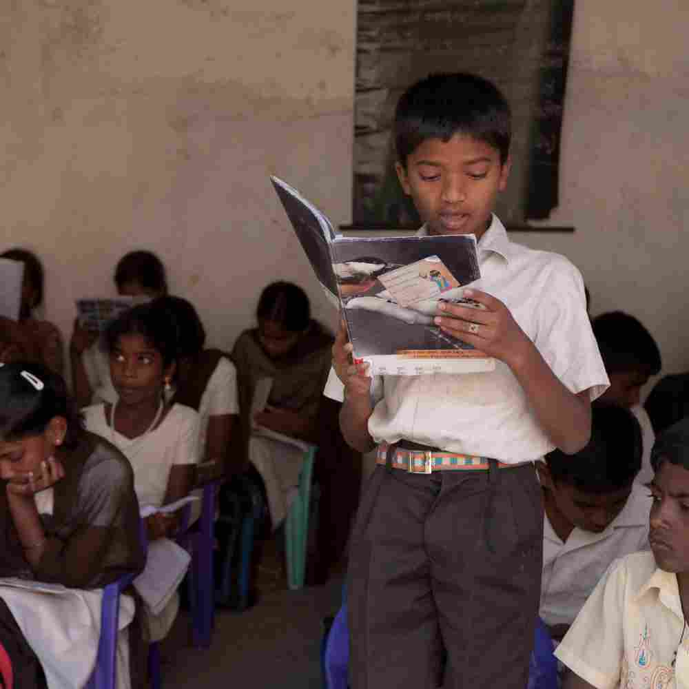 Young boy participates in GFA World Bridge of Hope child sponsorship class by reading