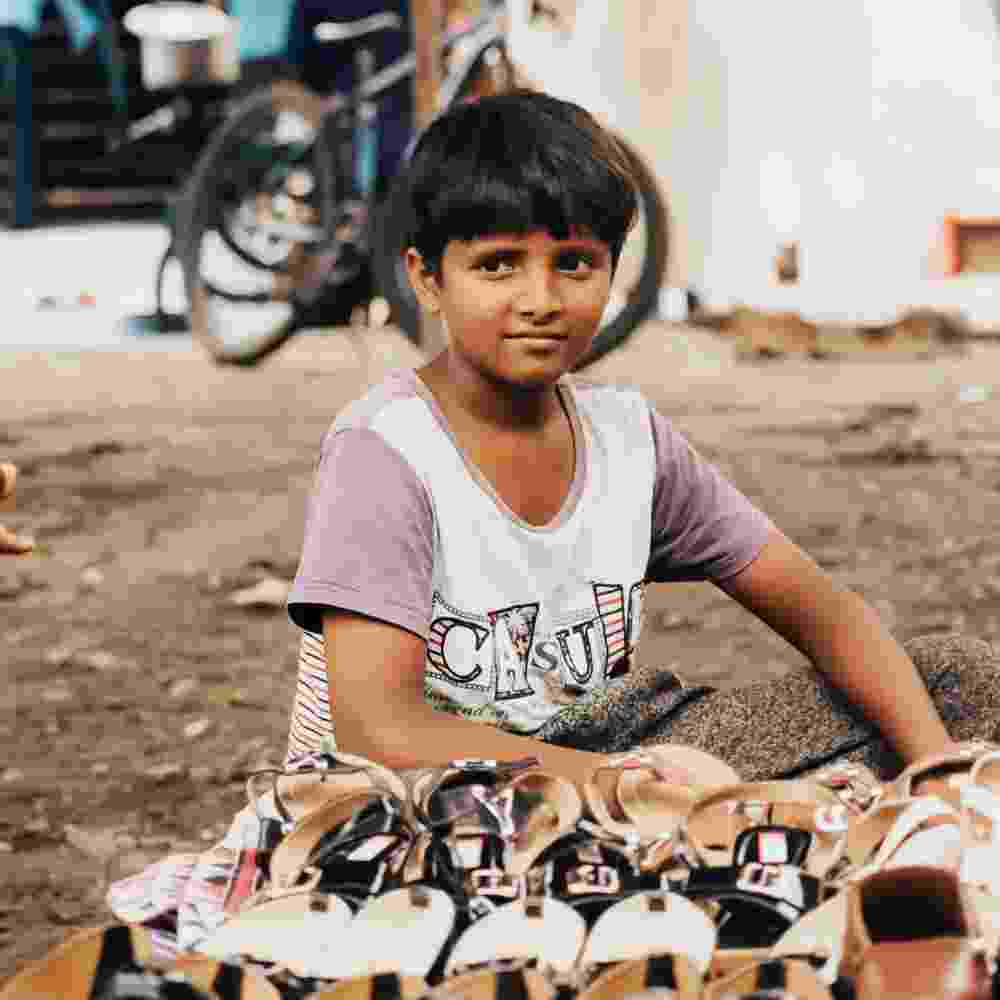 A young boy helps sell shoes