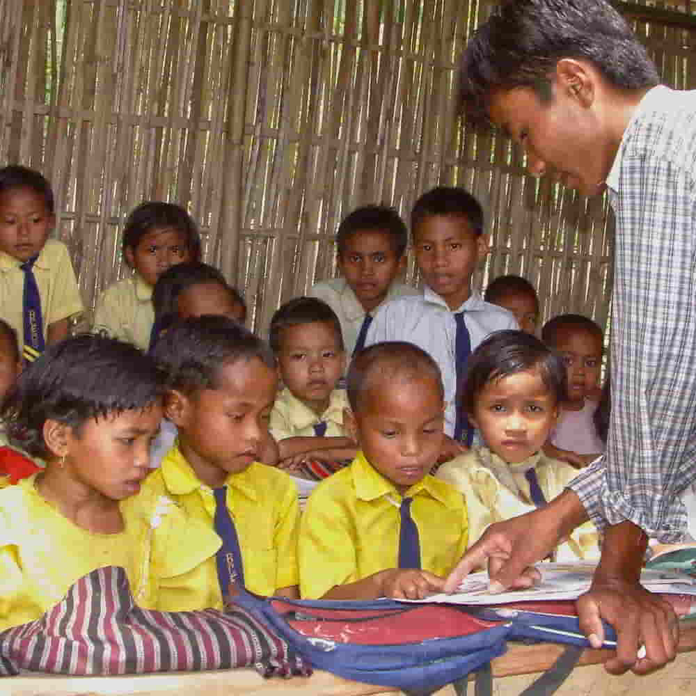 Teacher instructing children in GFA World child sponsorship Bridge of Hope