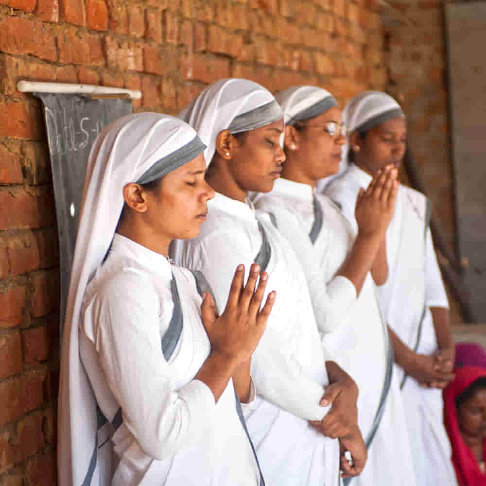 GFA World women missionaries praying before starting the adult literacy class