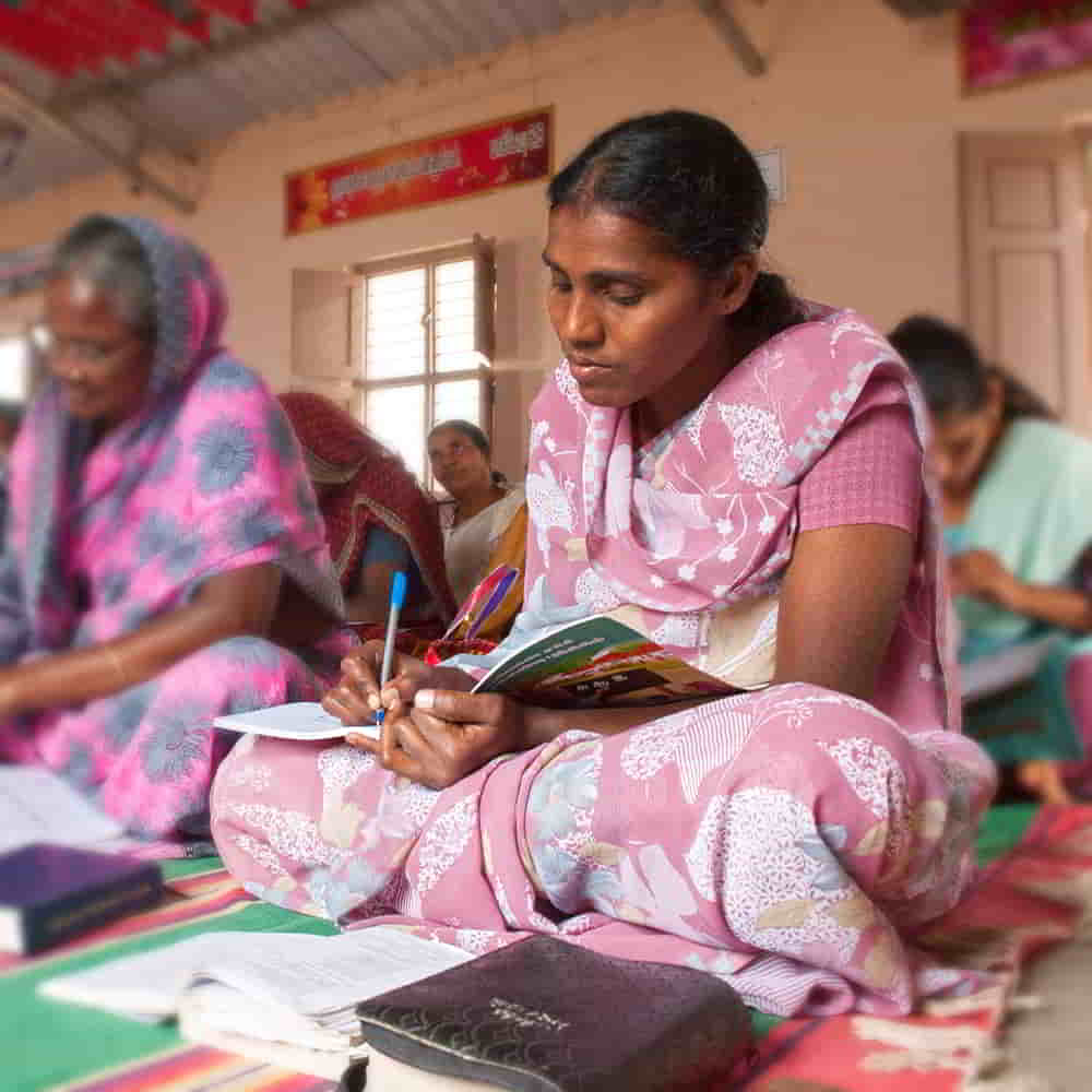 Woman writing in GFA World adult literacy class