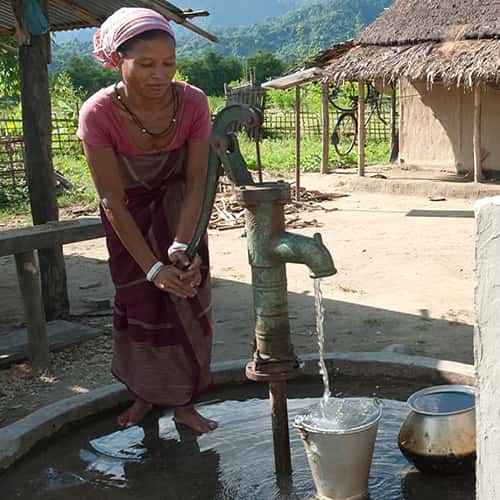 Woman fills bucket with clean water through GFA World Jesus Wells