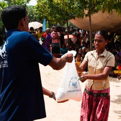Woman receives disaster relief supplies from GFA World (Gospel for Asia)