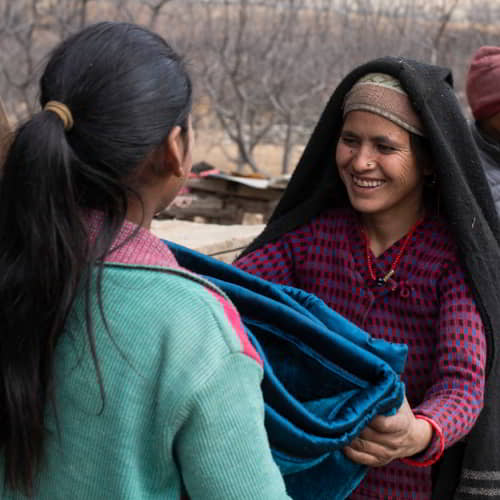 Woman from Nepal receives a warm blanket through GFA World gift distribution