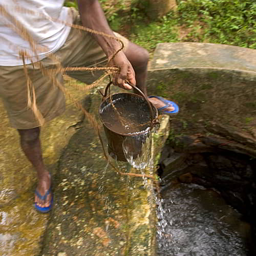 Drawing contaminated water from an open water well in Sri Lanka