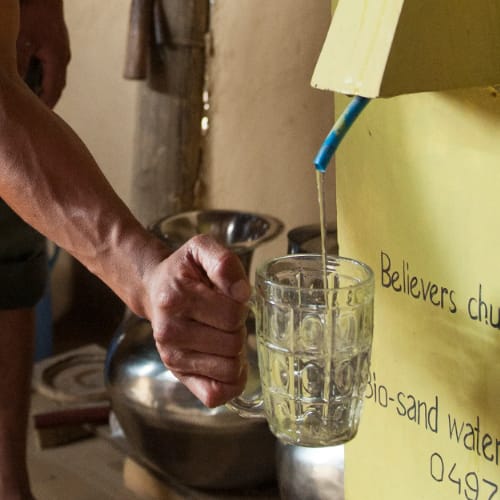 Man collects clean water through GFA World Biosand Water Filter