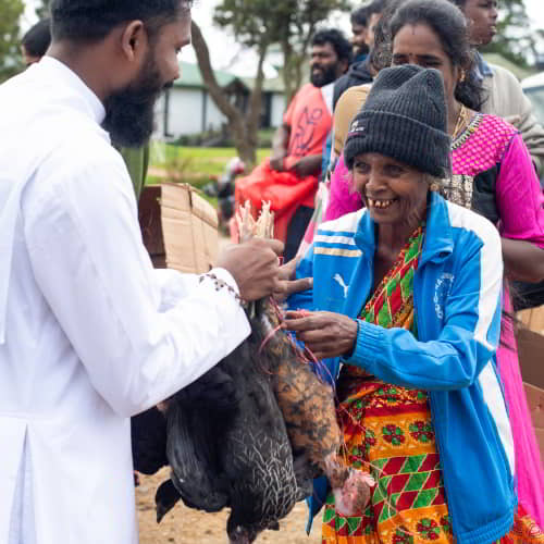 Woman from Sri Lanka receives a pair of income generating chickens through GFA World gift distribution