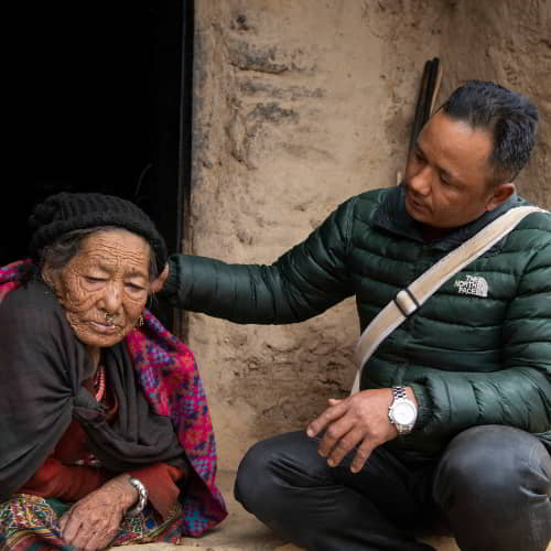 GFA World national missionary from Nepal prays and shares the love of Jesus to an elderly woman in poverty
