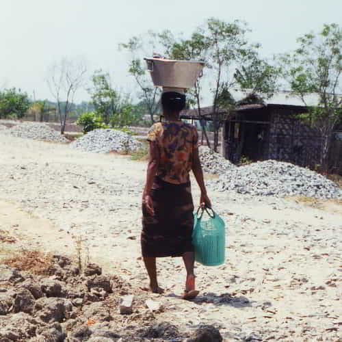 Woman in poverty walking long distances to collect water