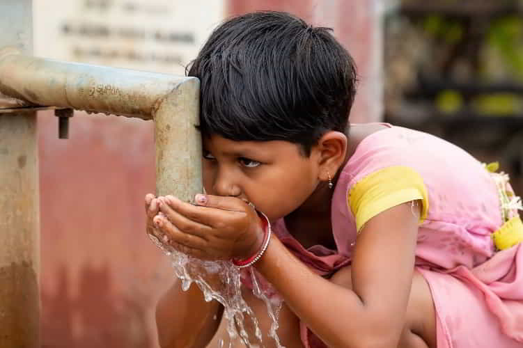 Young girl drinking clean water through GFA World Jesus Wells