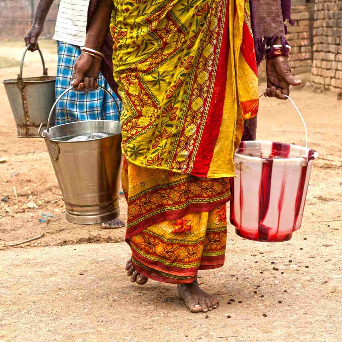 Woman walking carrying buckets of water