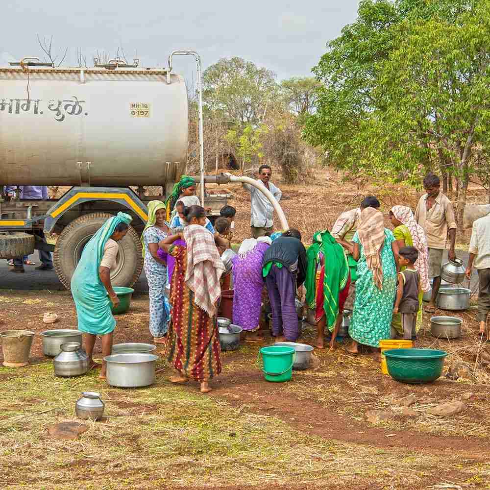 People of all ages and gender come to the water tanker and try to fill as much water as they can as their region suffers from acute drought.