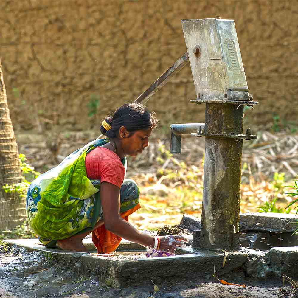 Woman enjoys the clean water benefits of GFA World Jesus Wells.
