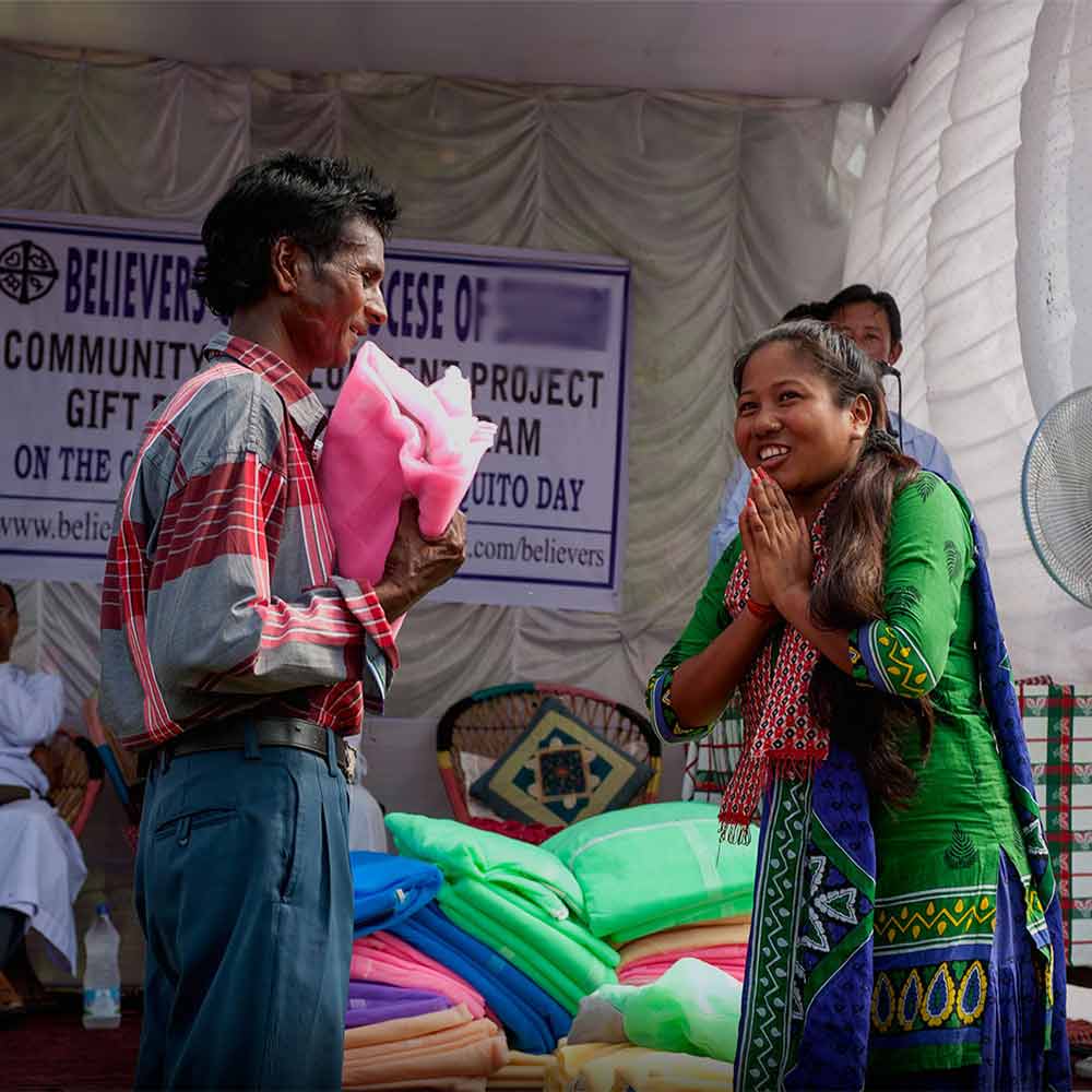 This woman is beaming with joy as she receives a mosquito net through a GFA World gift distribution.
