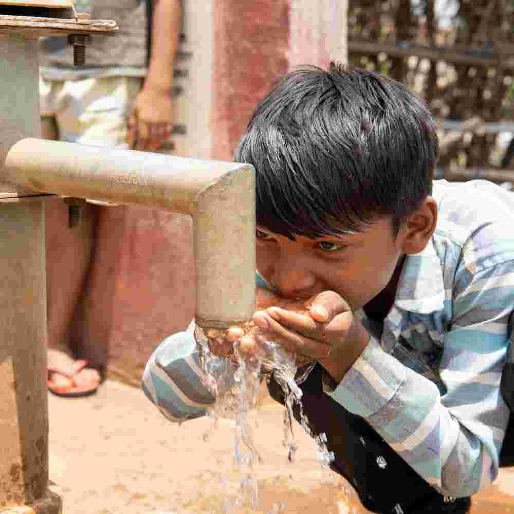 Young boy drinking clean water from GFA World Jesus Wells