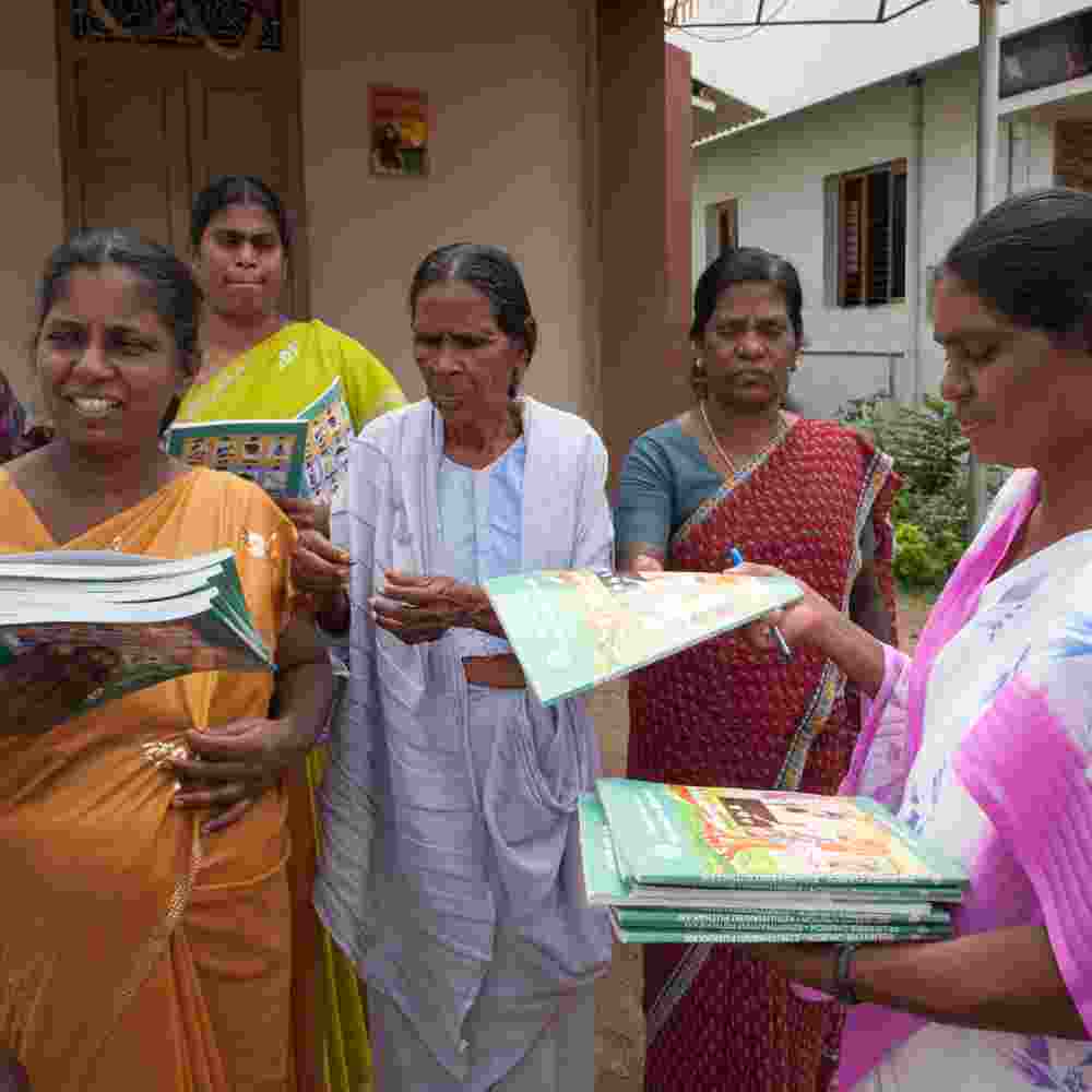 Distributing free literacy workbooks to women adult literacy class students