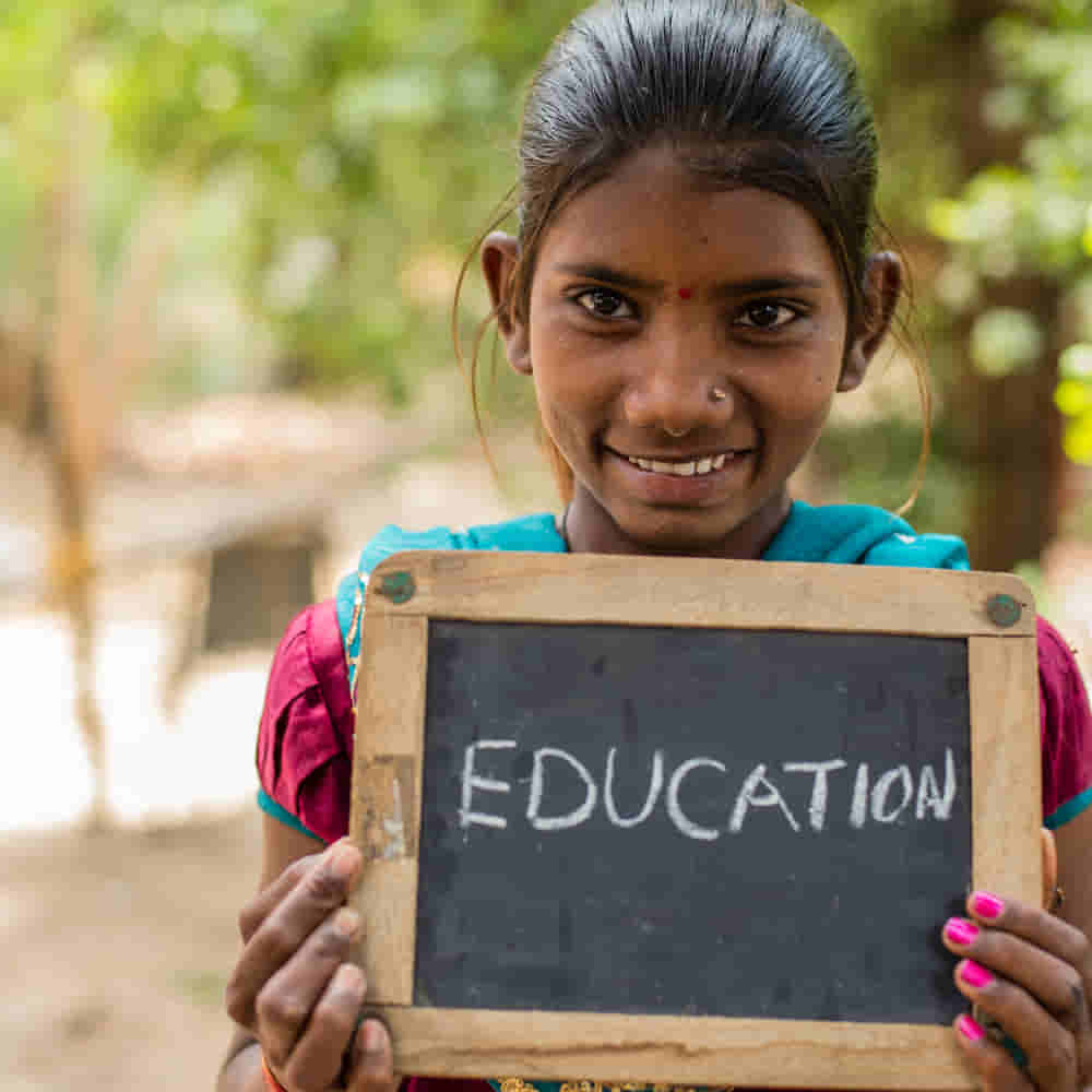 Young girl holding a chalkboard with Education written