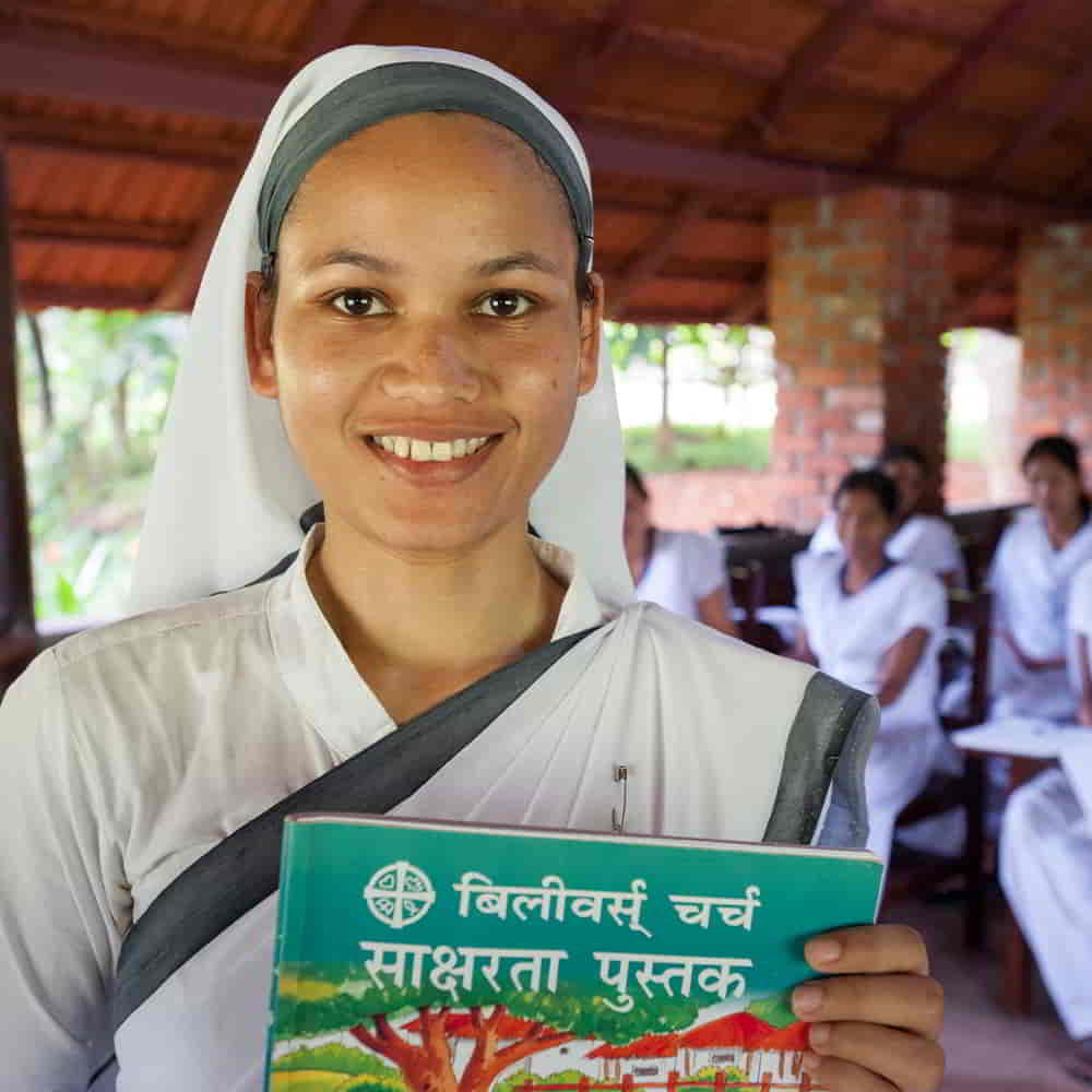 GFA World woman missionary holding adult literacy class workbook