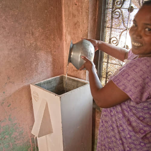 Woman draws clean water through GFA World BioSand water filter