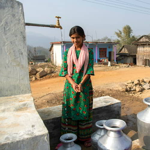 Young woman from Nepal collecting clean water through GFA World Jesus Wells
