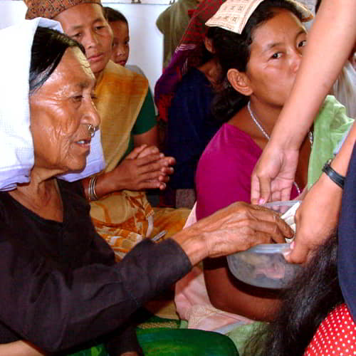 Woman in poverty giving in a church in Nepal