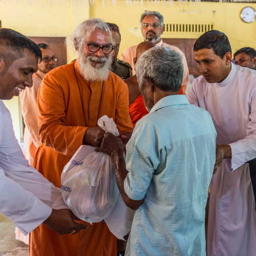 GFA World founder KP Yohannan assists in distributing relief supplies to people in poverty