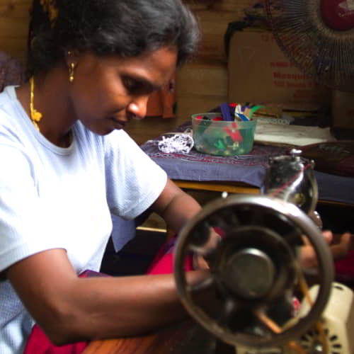 Women learn to use a sewing machine through GFA World vocational training